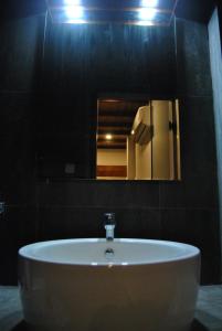 a white sink in a bathroom with a mirror at The Canoe in Negombo