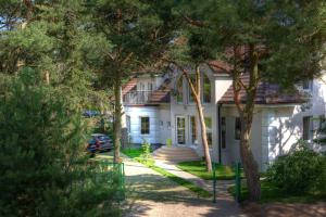 a white house with a car parked in the driveway at Morska Fala in Pobierowo