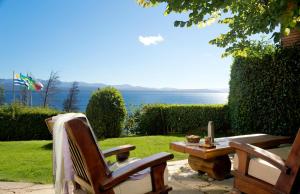 a patio with a table and chairs and the ocean at Pailahue Cabañas Lodge in San Carlos de Bariloche