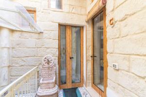 a wooden door on a building with a staircase at Dimora Corte antica in Scorrano