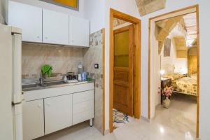 a kitchen with a sink and a bedroom at Dimora Corte antica in Scorrano