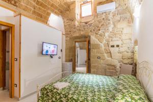 a bedroom with a bed in a stone wall at Dimora Corte antica in Scorrano