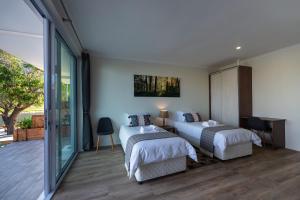een slaapkamer met 2 bedden en een balkon bij Marina Views in Muizenberg
