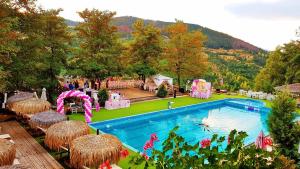 a swimming pool with a playground and a resort at Mountain View Hotel Complex in Yabulkovets