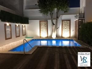 a swimming pool in a house with a tree at Villa Rio Guest House Suites in Portimão