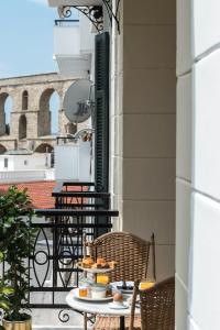 einen Tisch mit Tellern aus Essen auf einem Balkon in der Unterkunft The Anthemion House in Kavala