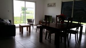 uma sala de jantar com uma mesa e cadeiras e uma janela em Gite du patureau em Belleray