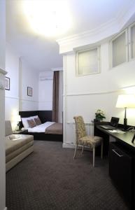 a hotel room with a bed and a desk and a couch at Booking Rooms in Belgrade