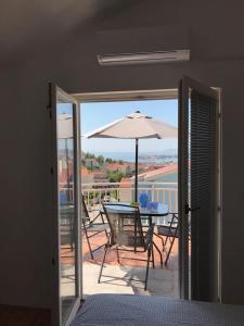 a balcony with a table and an umbrella at Vacation Rentals Croatia in Split