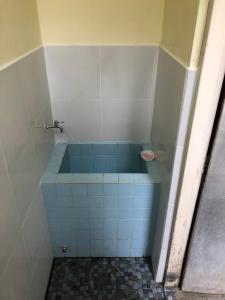 uma casa de banho com um chuveiro e uma banheira azul em Astani Family Home em Bukittinggi