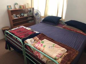 1 Schlafzimmer mit 2 Einzelbetten und einem Ventilator in der Unterkunft Astani Family Home in Bukittinggi