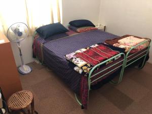 ブキティンギにあるAstani Family Homeのベッドルーム1室(青いシーツとファン付きのベッド1台付)