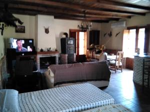 Una sala de estar con un sofá y un televisor. en Estudio Rustico, en Tabernas