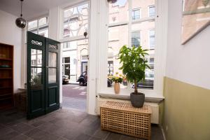 a door to a building with a potted plant in a window at Aan de Dieze in Den Bosch