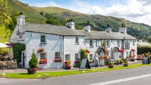 ein weißer Gasthof am Straßenrand in der Unterkunft The Traveller's Rest in Grasmere