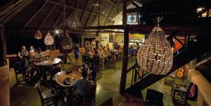 a group of people sitting at tables in a restaurant at Eco Venao Lodge, Playa Venao in Playa Venao