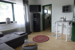 a living room with a couch and a kitchen at Ver-Reiss-t in Korlingen