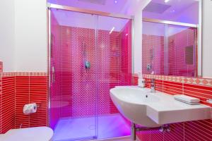 bagno con lavandino e doccia con piastrelle rosa di Villa Paradise Resort ad Agerola