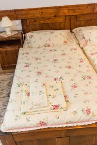 Una cama con sábanas blancas con flores. en Penzión Gazdovský Hostinec, en Topoľčianky