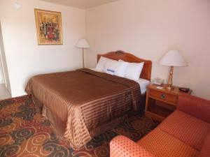 a hotel room with a bed and a chair at Americas Best Value Inn Santa Rosa, New Mexico in Santa Rosa