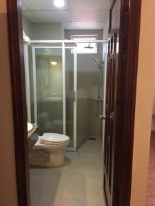 a bathroom with a toilet and a glass shower at Tan Hoang Gia Hotel in Phu Quoc