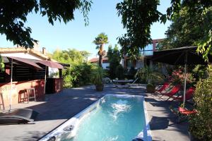 a swimming pool in a yard with a table and an umbrella at Bed and Breakfast Shandita in Mérignac