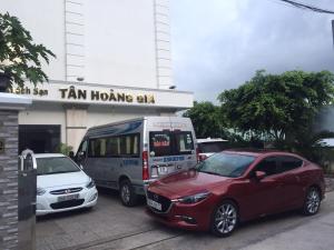 富國的住宿－Tan Hoang Gia Hotel，两辆汽车停在公共汽车旁边的停车场