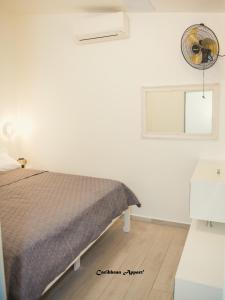 a white bedroom with a bed and a window at Caribbean Appart' in Le Moule