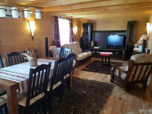 een woonkamer met een tafel en een televisie bij Casa de la Lac in Sighetu Marmaţiei