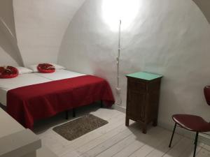 - une petite chambre avec un lit rouge et une table dans l'établissement casa della notara, à Alezio