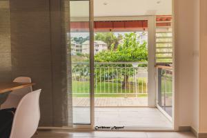 Habitación con una puerta corredera de cristal que da a un balcón. en Caribbean Appart', en Le Moule