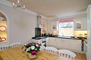 a kitchen with a table with a vase of flowers at Lady Margaret's in Bath