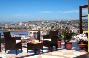 a patio with chairs and a table on a balcony at Hotel Boutique Acontraluz in Valparaíso
