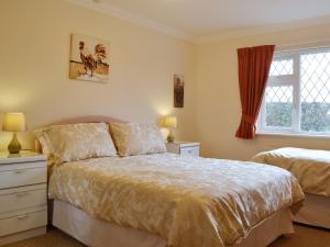 A bed or beds in a room at Benjay Cottage 