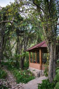 un pequeño edificio en medio de algunos árboles en Eco Lodge Los Perales-Urubamba, en Urubamba