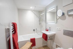 a white bathroom with a sink and a shower at Hotel Garni Jägerhof in Sigmaringen