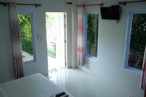ノーンカーイにあるKhong Chom Janのベッドルーム1室(窓2つ、ベッド1台、テレビ付)