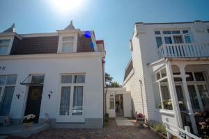 Biały dom obok białego budynku w obiekcie The Bond Studio FREE PARKING w Zandvoort