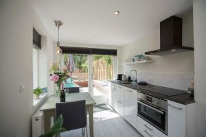 a kitchen with white cabinets and a table with a counter top at The Bond Studio FREE PARKING in Zandvoort