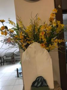 a vase filled with flowers sitting on a table at Vital Hotel in Marechal Floriano