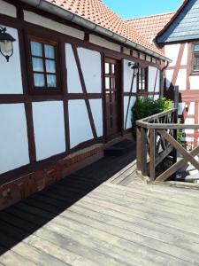 eine Veranda eines Hauses mit einer Holzterrasse in der Unterkunft Diebacher Hof in Büdingen