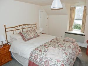 A bed or beds in a room at Woodbine Cottage 
