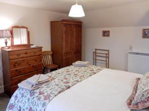 A bed or beds in a room at Woodbine Cottage 