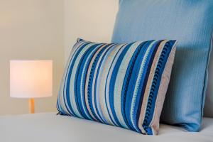 ポルトにあるTrindade Modern Flatのベッド(ランプ付)の上に置かれた青と白の枕