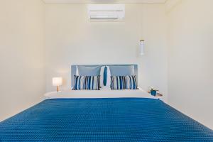 uma cama azul e branca num quarto branco em Trindade Modern Flat no Porto