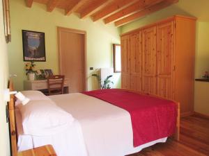 - une chambre avec un grand lit blanc et une armoire en bois dans l'établissement Antica Osteria Pace, à Moerna