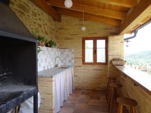 a kitchen with a sink and a counter with stools at Casa L'Apargatero in Morillo de Monclús