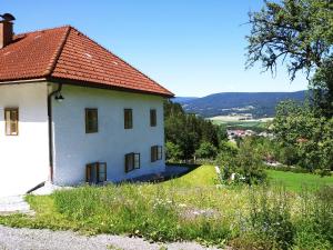 a white house with a red roof on a hill at Ferienhaus Herrnbauer in Zaglau