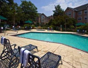 a pool with chairs and a pool table in it at Poplar Inn and Suites in Memphis