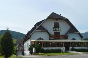 a large white building with a black roof at Motel Gombáš in Hubová